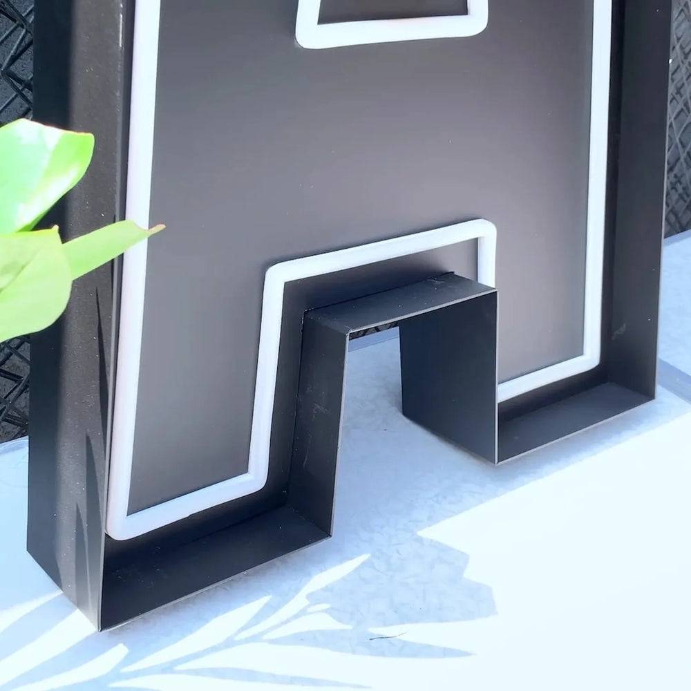 Fabricated channel letter standing on its side with the mounting hardware visible