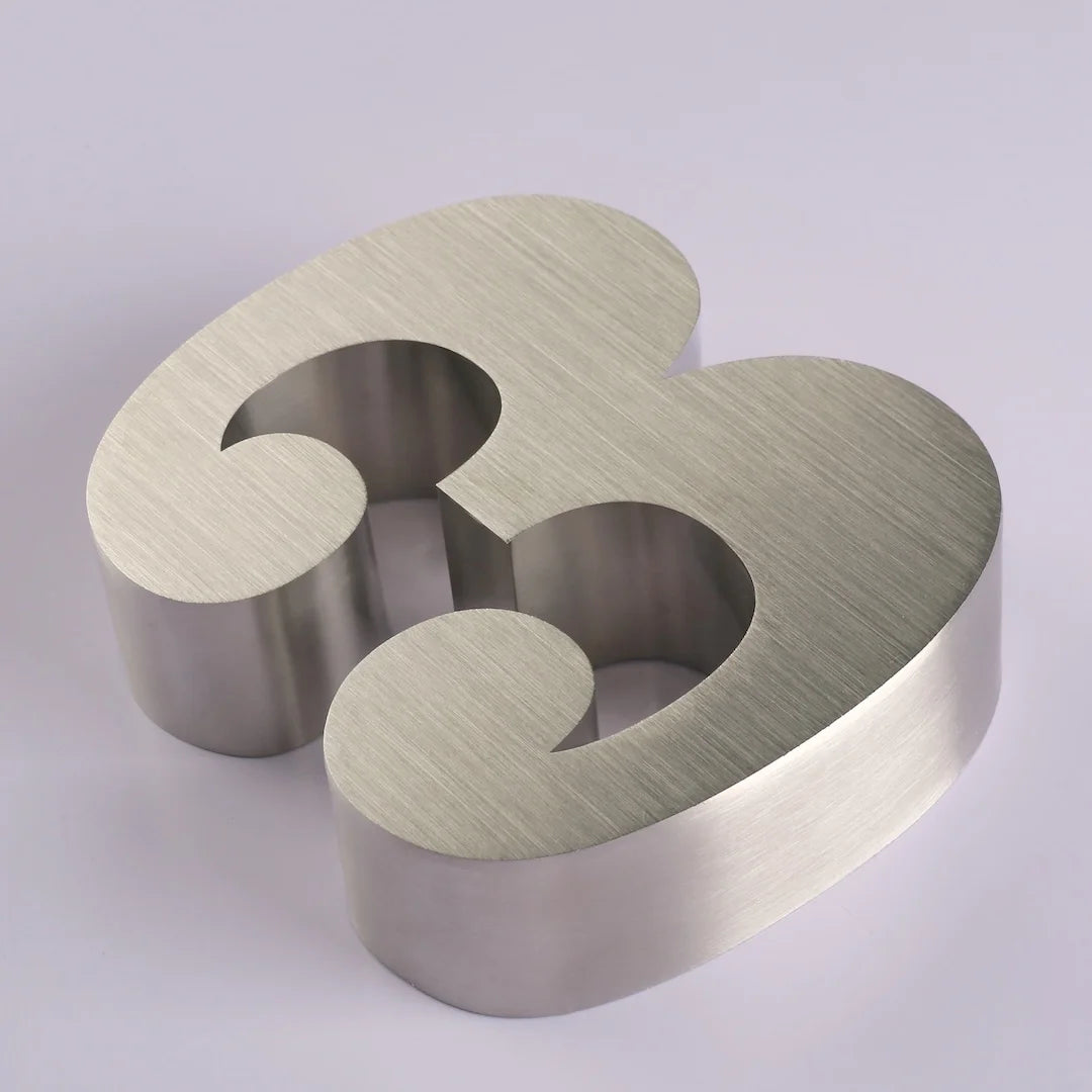 Custom 3D stainless steel letter with brushed silver finish, thick metal body, and rounded cut edges