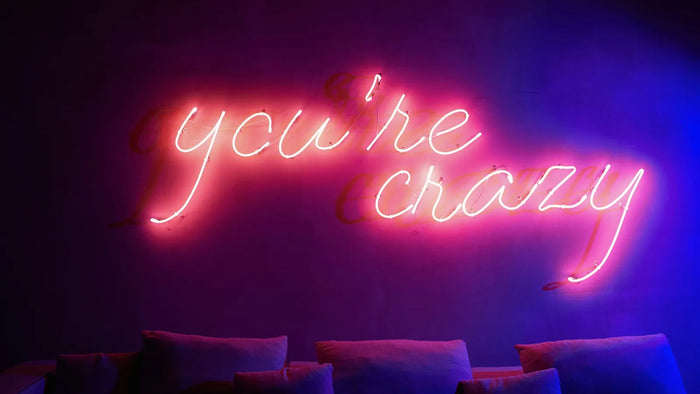 Real glass neon sign in pink script, the whole tube glowing evenly