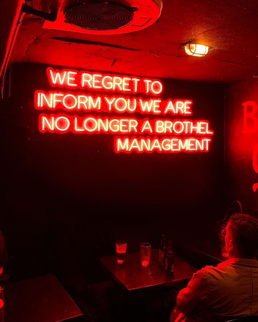 We Regret to Inform You We Are No Longer a Brothel Management Neon Sign